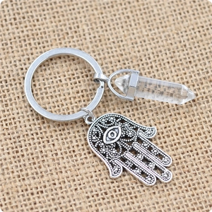 Détail de la main de Hamsa et du cristal blanc hexagonal sur un fond tissé