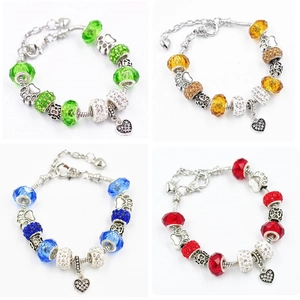 Dettaglio di bracciali con perle di vetro DIY e ciondoli corona in quattro colori