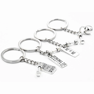 Macro detail of alloy fitness keychains with dumbbell, kettlebell and motivational tags