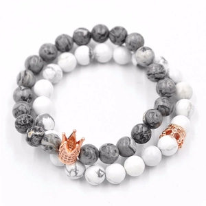 Détail de bracelets en perles de lave, turquoise blanche et couronnes en or rose