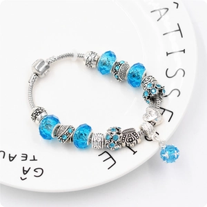 Dettaglio del bracciale a catena serpente con perle di cristallo blu e ciondoli a cuore