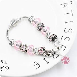 Dettaglio di perline in cristallo rosa e ciondolo a cuore su bracciale snake