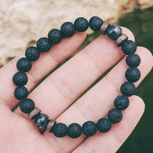 Détail d'un bracelet en pierre de lave 8mm avec entretoises métalliques et perles gemmes