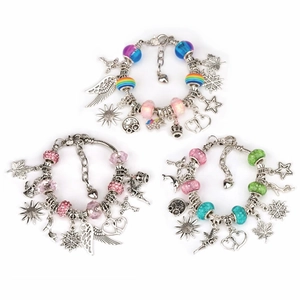 Gedetailleerde close-up van drie DIY-bedelarmbanden met metalen hangers en gekleurde kralen