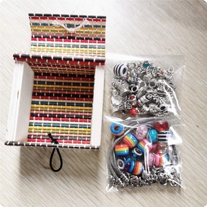 DIY sieradenset met zilveren bedeltjes en regenboogkralen in een gekleurde bamboe doos