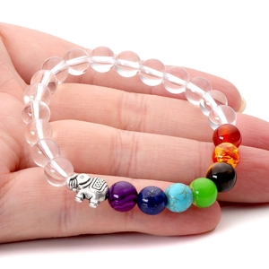 Macro detail of chakra healing crystal bracelet with silver elephant charm on a hand