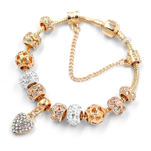 Detail of gold snake chain bracelet with sparkling crystal heart charms and hollow beads