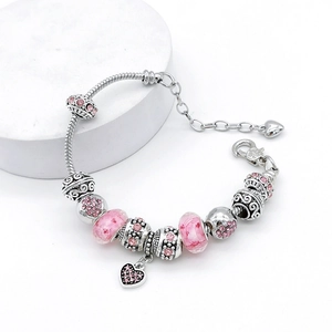 Bracelet à breloques cœur rose avec perles en résine et chaîne serpent sur socle blanc