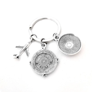 Macro shot of vintage silver keychain with airplane, compass and textured charms