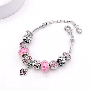 Gros plan détaillé des breloques cœur rose et perles cristal sur bracelet chaîne serpent