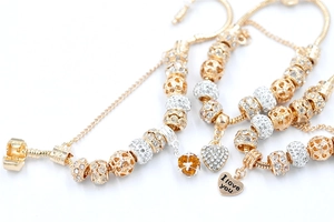 Detail of gold snake chain bracelet with heart charm and sparkling crystal beads