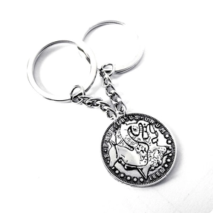 Macro detail of antique silver eagle coin keychain with 1886 engraving and dual rings