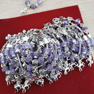 Detailed view of purple crystal beads and unicorn charms on silver snake chain bracelets