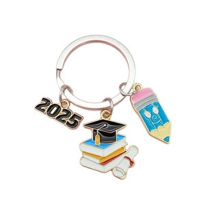 Porte-clés de remise de diplôme 2025 avec toque de docteur sur livres et breloque crayon