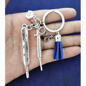 Medical theme keychain with syringe thermometer and stethoscope charms on blue tassel