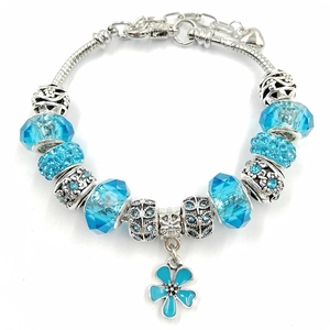 Detailed macro view of silver snake chain bracelet with blue crystal beads and flower charm