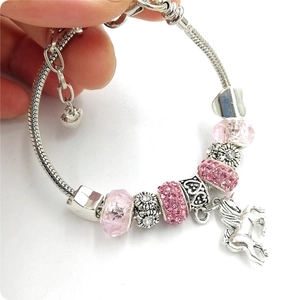 Close-up of pink crystal beads and unicorn pendant on silver-plated snake chain