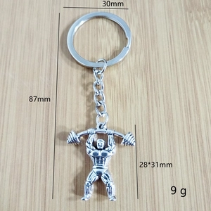 Porte-clés fitness avec pendentif culturiste et haltère sur fond en bois