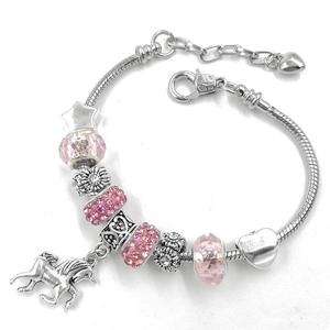 Detailed macro view of silver unicorn charm bracelet with pink crystal beads and snake chain
