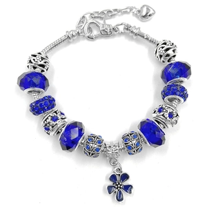 Close-up of blue crystal beads and clover charm on a silver-tone DIY charm bracelet