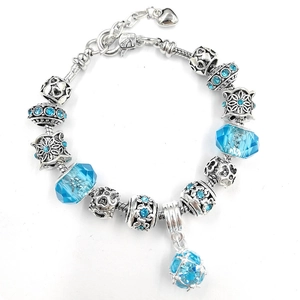 Dettaglio del bracciale a maglia serpente argento con perle di cristallo blu e stella