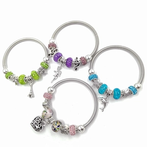 Vue à plat de quatre bracelets élastiques en perles DIY avec charms dauphin et cœur