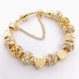 Pulsera de cadena de serpiente dorada con cuentas de cristal, corazones y una carita