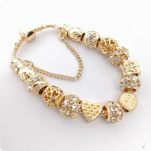 Detalle de la pulsera dorada de cadena de serpiente con cuentas de cristal y lazo