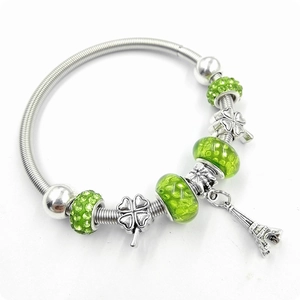Détail du bracelet à breloques avec strass verts et pendentif Tour Eiffel sur chaîne ressort