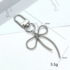 Detail showing silver bow keychain dimensions of 78mm by 36mm and 5.5g weight info