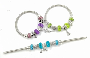 Détail de bracelets à breloques en maille serpent avec perles et pendentifs colorés