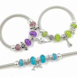 Trois bracelets à breloques perles avec dauphins et cœurs sur anneaux en acier inox
