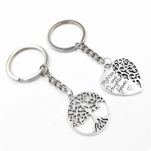 Detail of puzzle piece heart and tree of life pendants with Mother and Daughter engraving