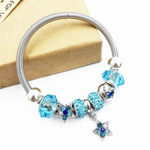 Close-up of DIY charm bracelet with blue crystal beads and snowflake star pendants