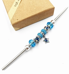 Detailed view of blue crystal beads and silver star pendants for DIY charm bracelets