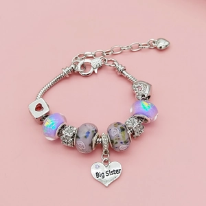 Détail d'un bracelet à breloques DIY avec perles violettes et pendentif Big Sister
