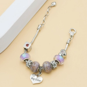 Détail du bracelet licorne avec perles violettes et pendentif coeur Big Sister