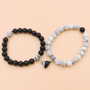 Detail der Magnet-Herzanhänger an schwarz-matten und weißen Marmorperlen-Armbändern