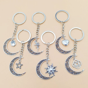 Detailed view of six vintage silver hollow moon keychains with sun and star charms