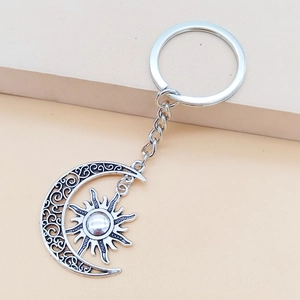 Macro detail of vintage silver moon and sun keychain with intricate hollow carvings