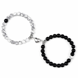 Makro-Detailansicht der Partnerarmbänder mit weißen und schwarzen Perlen und Herz-Magnet