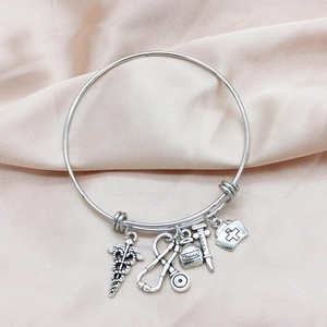 Adjustable silver nursing bracelet with medical charms like stethoscope and nurse hat on silk