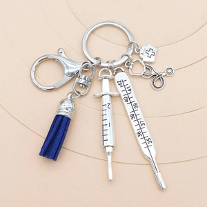 Close-up of a medical keychain with syringe, thermometer, stethoscope and blue tassel