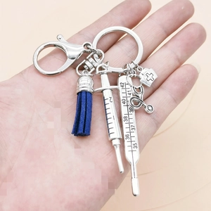Nurse themed silver keychain with blue tassel, syringe, stethoscope and medical charms