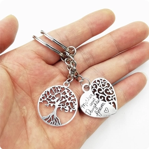 Close-up of Mother and Daughter forever engraved heart and tree of life keychains