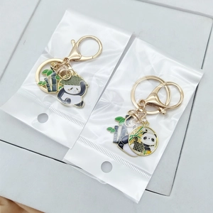 Detail of panda bamboo keychains with gold-tone enamel finish in clear packaging