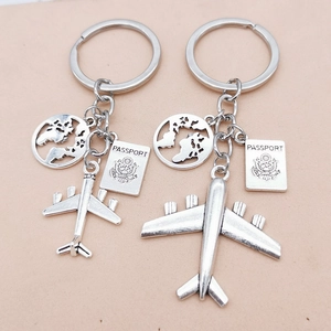 Silver alloy travel keychain set featuring airplane, passport, and globe pendants