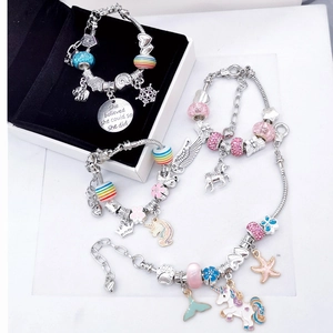 Dettaglio di quattro bracciali con ciondoli colorati, unicorni e dischi motivazionali