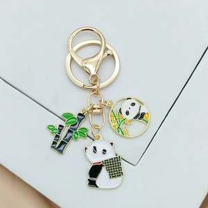 Close-up of golden panda keychain with bamboo pendants and enamel detailing on ring