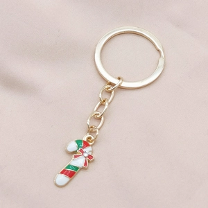Detail of Christmas candy cane keychain in gold alloy with red and white enamel finish